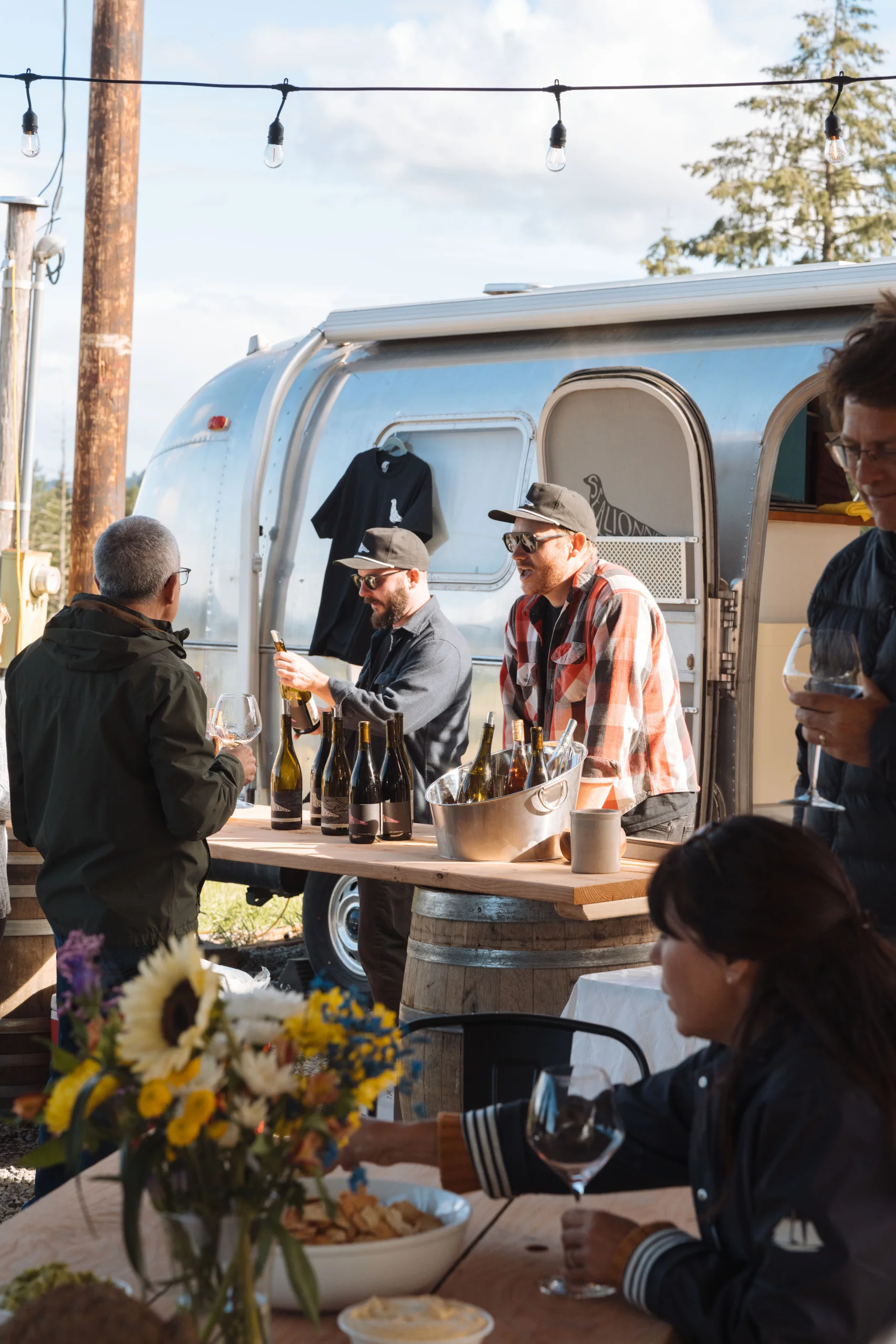 Guests tasting wine at a table beside the Airstream at West Wind