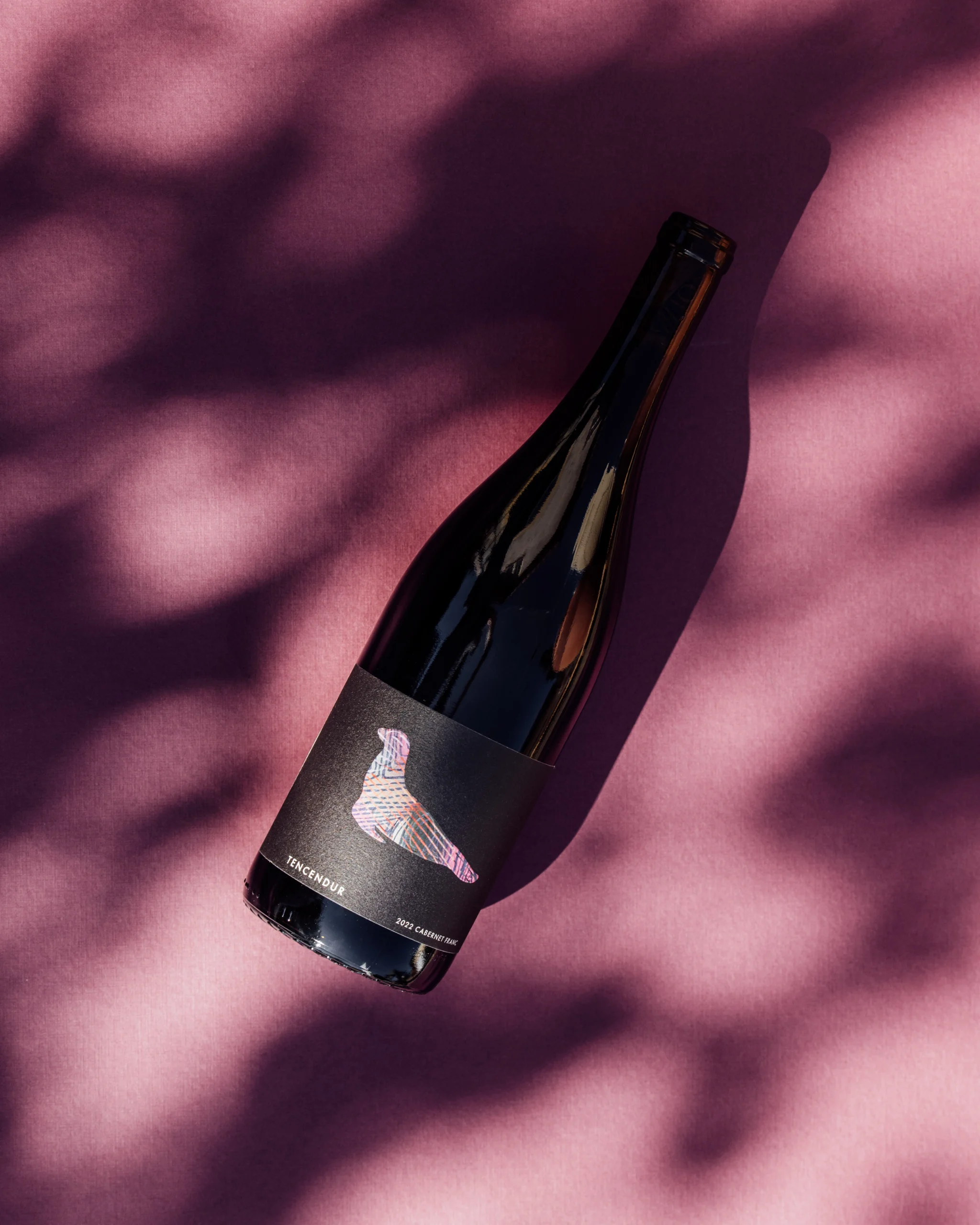 A Sealionne bottle lying in dappled light on a plum-colored table