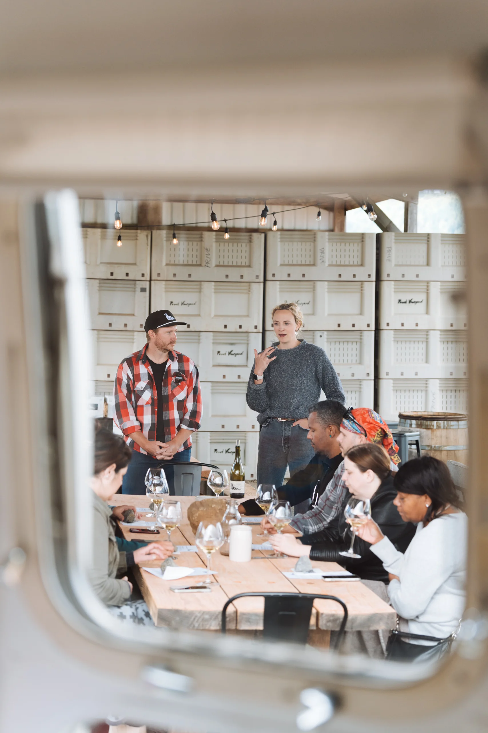 The crew tasting around a table, seen in a mirror